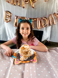 young girl with pluch cat and decorations a table