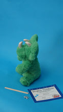Charger l'image dans la visionneuse de la galerie, Green plush dinosaur with a certificate on a blue background