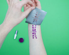 Load image into Gallery viewer, A temporary glitter tattoo on arm