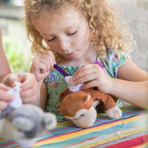 child stuffing her plush monkey at social distancing party 